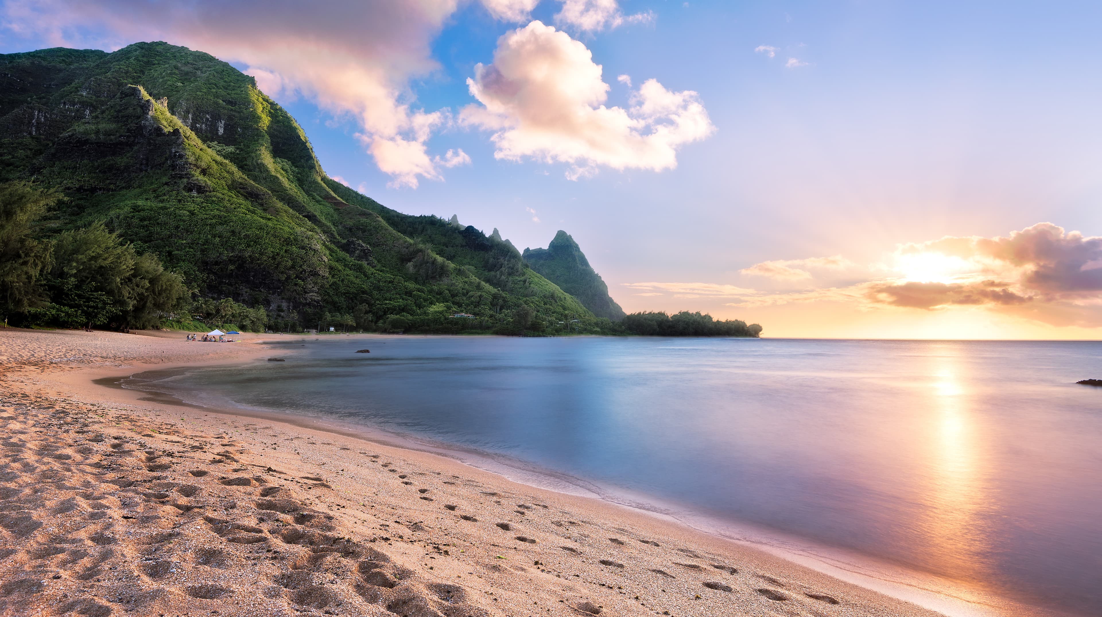 Sunset over a Hawaii beach and green mountain ridge